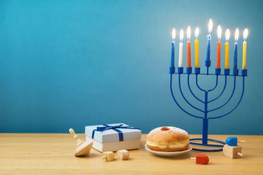 Yahudi tatil Hanukkah menorah, sufganiyot, hediye kutusu ve ahşap masa üstünde eğirme üstleri ile arka plan
