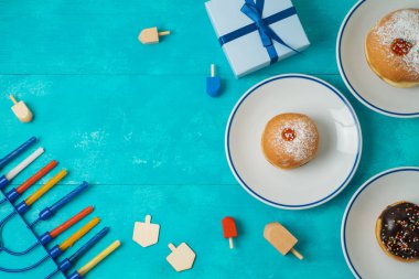 Yahudi tatil Hanukkah menorah, sufganiyot, hediye kutusu ve ahşap masa üstünde eğirme üstleri ile arka plan
