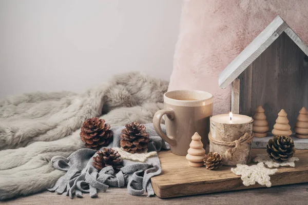 Hygge Scandinavian style concept with coffee cup, candle and pine cones. Cozy winter or Christmas composition