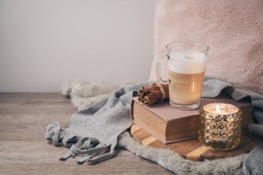 Hygge İskandinav tarzı konseptiyle latte macchiato kahve Kupası, mum ve kitap. Sıcacık kış veya sonbahar kompozisyon