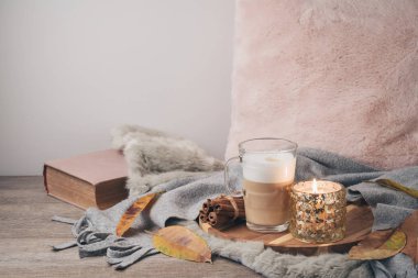 Hygge İskandinav tarzı konseptiyle latte macchiato kahve Kupası, mum ve kitap. Sıcacık kış veya sonbahar kompozisyon