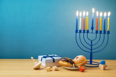 Yahudi tatil Hanukkah menorah, sufganiyot, hediye kutusu ve ahşap masa üstünde eğirme üstleri ile arka plan
