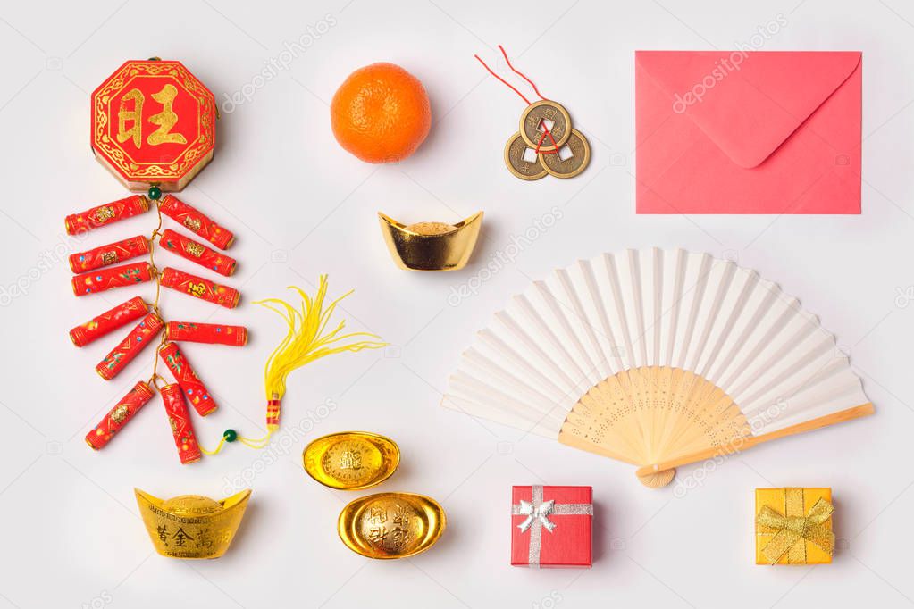 Chinese New Year concept with traditional decorations for Spring festival organized on white background. Top view from above. Chinese text: fortune, good luck and wealth.