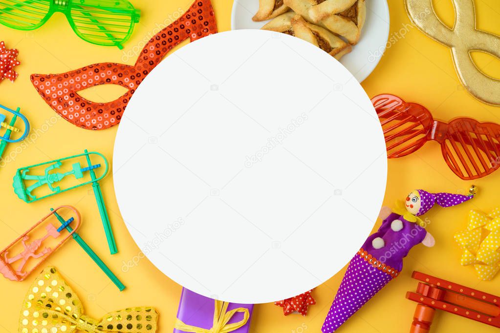 Jewish holiday Purim background with carnival mask, noisemaker and hamantaschen cookies. Top view from above. Flat lay