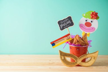 Yahudi tatil kova, karnaval maskesi, ahşap masa şenlikli ve hamantaschen çerezleri Purim arka plan. Yaratıcı Purim sepet fikir