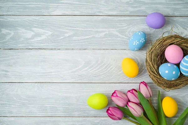 Fondo de vacaciones de Pascua con huevos de Pascua en nido de aves y tuli —  Fotos de Stock