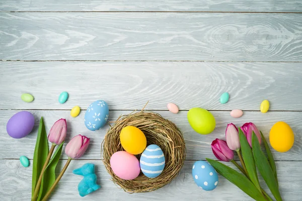 Fondo de vacaciones de Pascua con huevos de Pascua en nido de aves y tuli — Foto de Stock