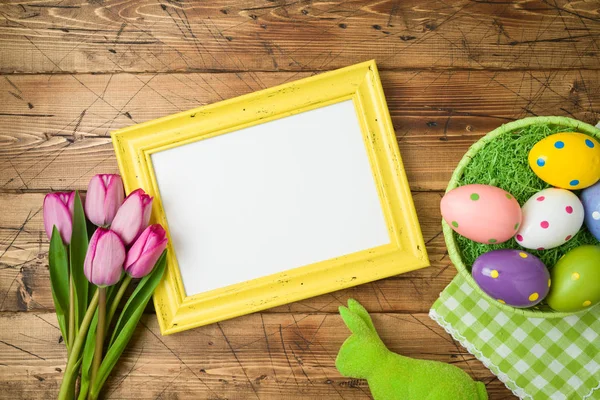 Fondo de vacaciones de Pascua con marco de fotos; huevos de Pascua en baske — Foto de Stock