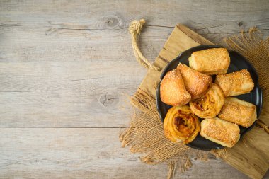Ahşap sekmesinde peynir, patates ve pizza ruloları ile dolu Burekas