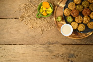 Ahşap tahta üzerinde tahin sos ile falafel topları. Üst görünüm