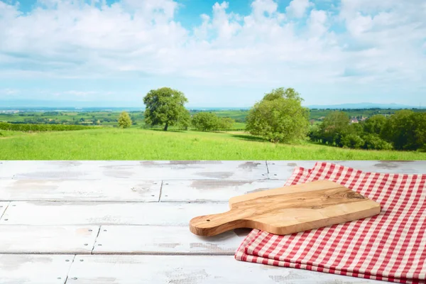 Mesa de madeira vazia com tábua de corte e toalha de mesa durante o verão — Fotografia de Stock