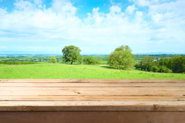 夏の草原の背景上の空の木製のテーブル — ストック写真