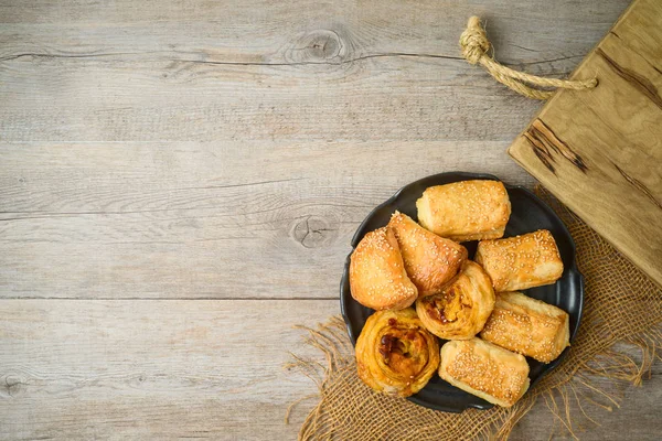 Burekas filled with cheese, potato and pizza rolls on wooden tab — Stock Photo, Image