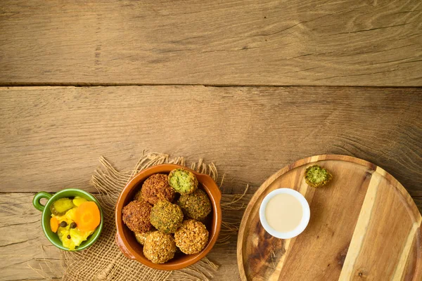 Falafel balls with tahini sauce on wooden board. Top view from a — Stock Photo, Image