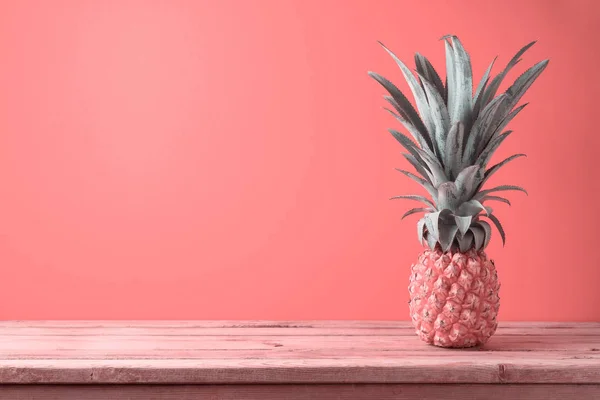 Summer concept with pineapple on wooden table over coral color b — Stock Photo, Image