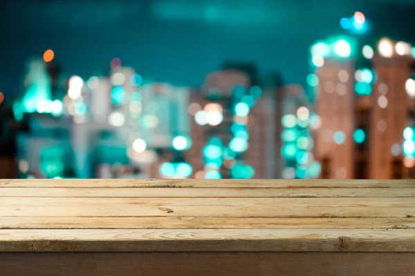 Empty wooden table over night city bokeh background — Stock Photo, Image