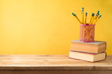 Ahşap t üzerinde kalem ve eski kitaplar ile okul arka plan geri