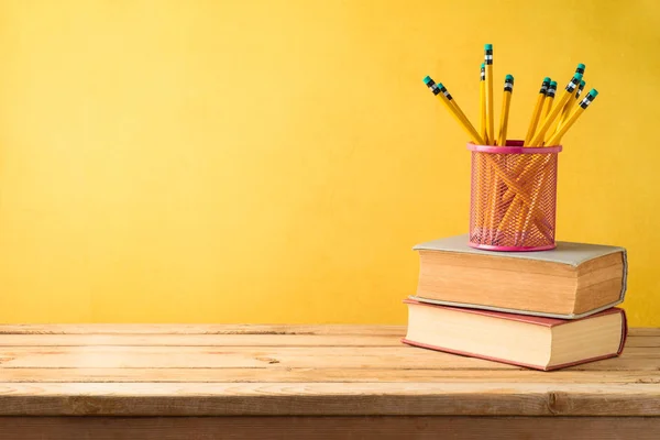 Terug naar school achtergrond met potloden en oude boeken op houten t — Stockfoto