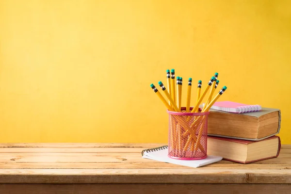 Voltar ao fundo da escola com lápis e livros antigos sobre t de madeira — Fotografia de Stock