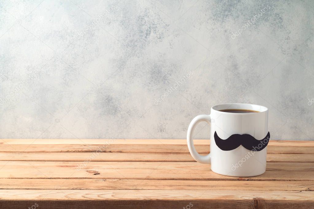 Happy Father's day concept with coffee mug and mustache over woo
