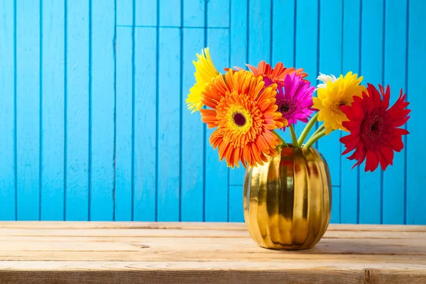 Πολύχρωμο μπουκέτο λουλουδιών σε χρυσό βάζο στο ξύλινο τραπέζι. — Φωτογραφία Αρχείου