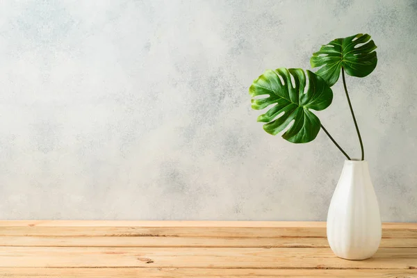 Tropische Blätter in Vase auf Holztisch — Stockfoto
