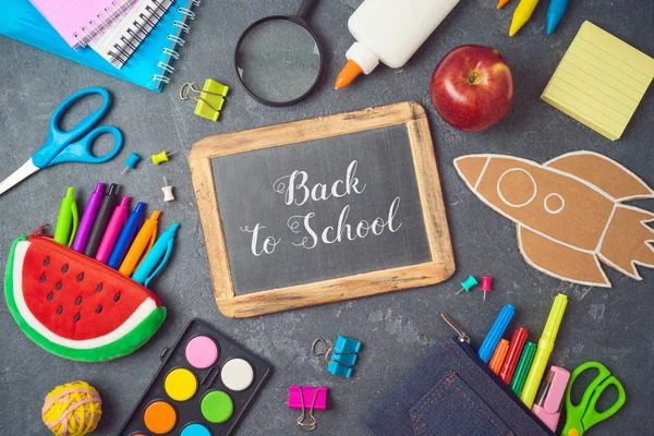 Tillbaka till skolan bakgrund med skolmaterial på blackboard. — Stockfoto