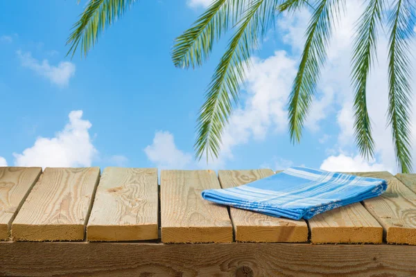 Empty wooden table with tablecloth over sea beach background — Stock Photo, Image