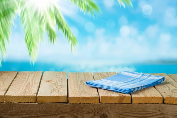 Leerer Holztisch mit Tischdecke über Meeresstrand Hintergrund — Stockfoto