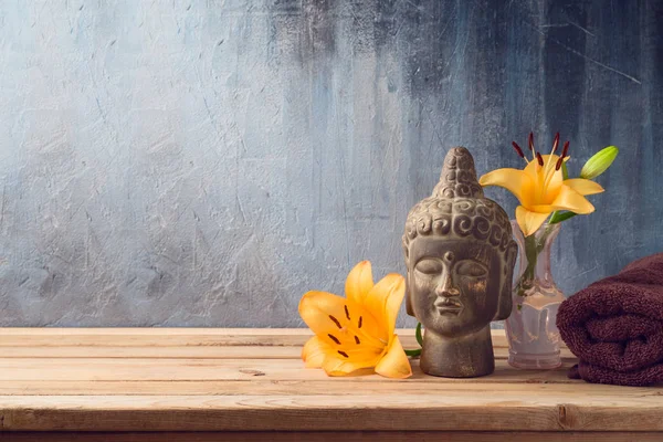 Buddha-Statue, Blumen und Handtuch auf Holztisch über dunklem Rücken — Stockfoto