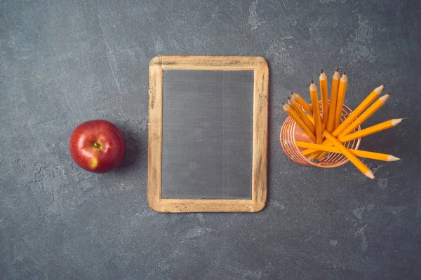 Volver a la escuela fondo con pizarra, lápices y manzana en — Foto de Stock