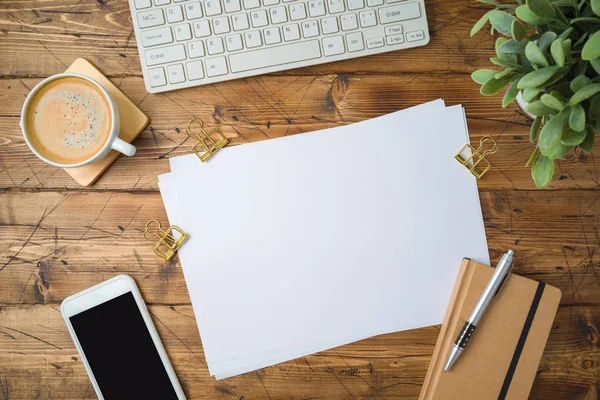 School papier met koffiekop, smartphone en plant op houten tabblad — Stockfoto