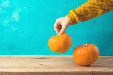 Ahşap masa ve kadın elinde kabak ile Sonbahar arka plan.