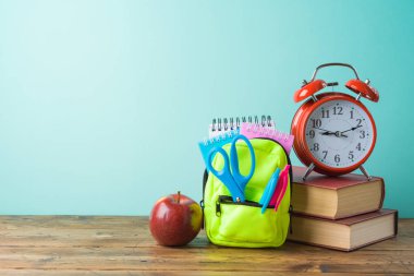 Geri küçük sırt çantası, kitap ve alarm c ile okul arka plan