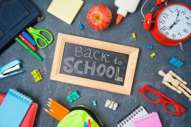 Tahta üzerinde okul malzemeleri ile Okul arka planda geri. Hedef