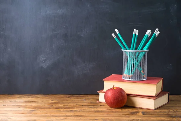 Возвращение в школу с ручкой, яблоком, книгами и будильником — стоковое фото