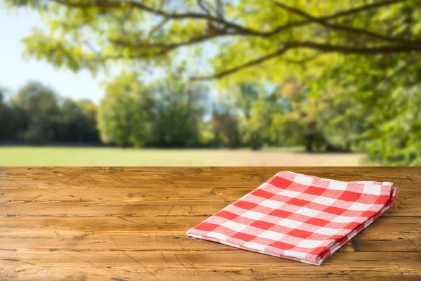 Tavolo in legno vuoto con tovaglia sul retro del parco naturale autunnale — Foto Stock