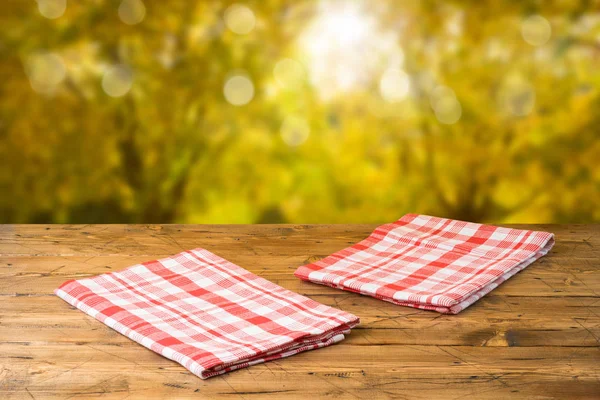 Empty wooden table with tablecloth over autumn nature park backg — Stock Photo, Image