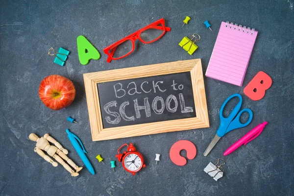 Ritorno a scuola con materiale scolastico sulla lavagna. Per — Foto Stock