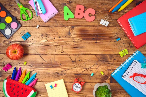 Volver al fondo escolar con útiles escolares en mesa de madera . — Foto de Stock