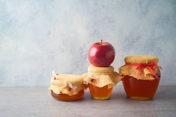 Honing potten en appel over grijze achtergrond — Stockfoto