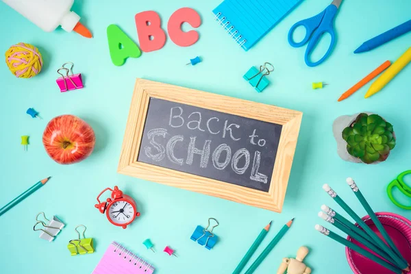 Voltar ao conceito de escola com material escolar sobre fundo azul — Fotografia de Stock