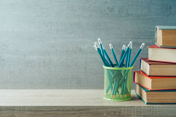 Концепция возвращения в школу с ручками и старыми книгами на деревянном шеле — стоковое фото