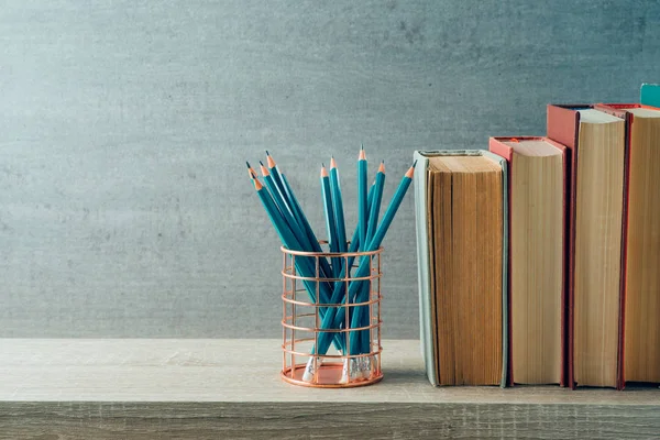 Voltar ao conceito de escola com lápis e livros antigos sobre shel de madeira — Fotografia de Stock