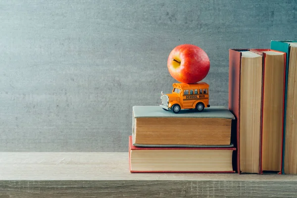 Powrót do szkoły koncepcji z zabawek autobus szkolny, jabłko i książki na w — Zdjęcie stockowe