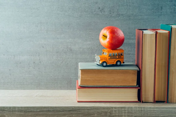 Concept de retour à l'école avec jouet d'autobus scolaire, pomme et livres sur w — Photo