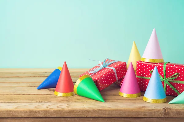 Birthday party background with gift boxes and party hats on wood — Stock Photo, Image