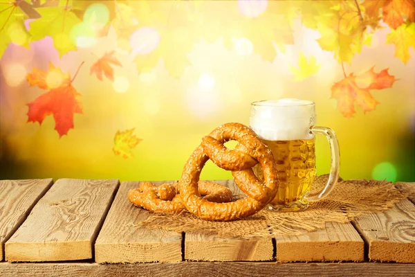 Oktoberfest concept with beer and pretzel on wooden table over a — Stock Photo, Image