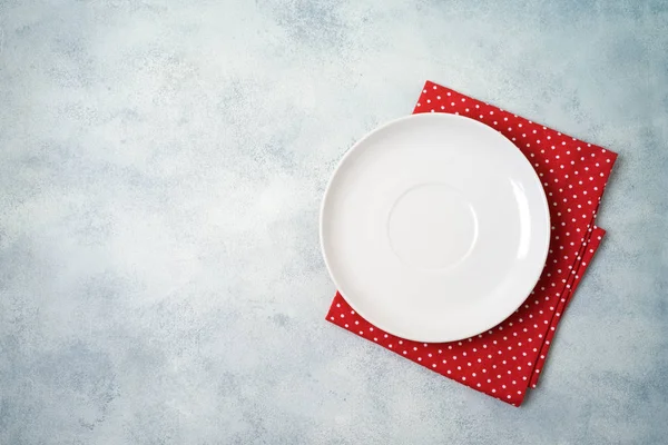 Empty white plate with tablecloth on gray stone table background — ストック写真