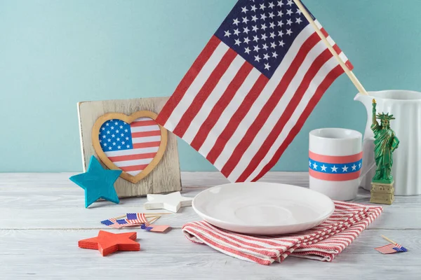 アメリカの国旗と装飾が施された木製のテーブルの上にストライプのテーブルクロスが付いている空のプレート 7月4日アメリカ独立記念日モックアップのデザイン — ストック写真